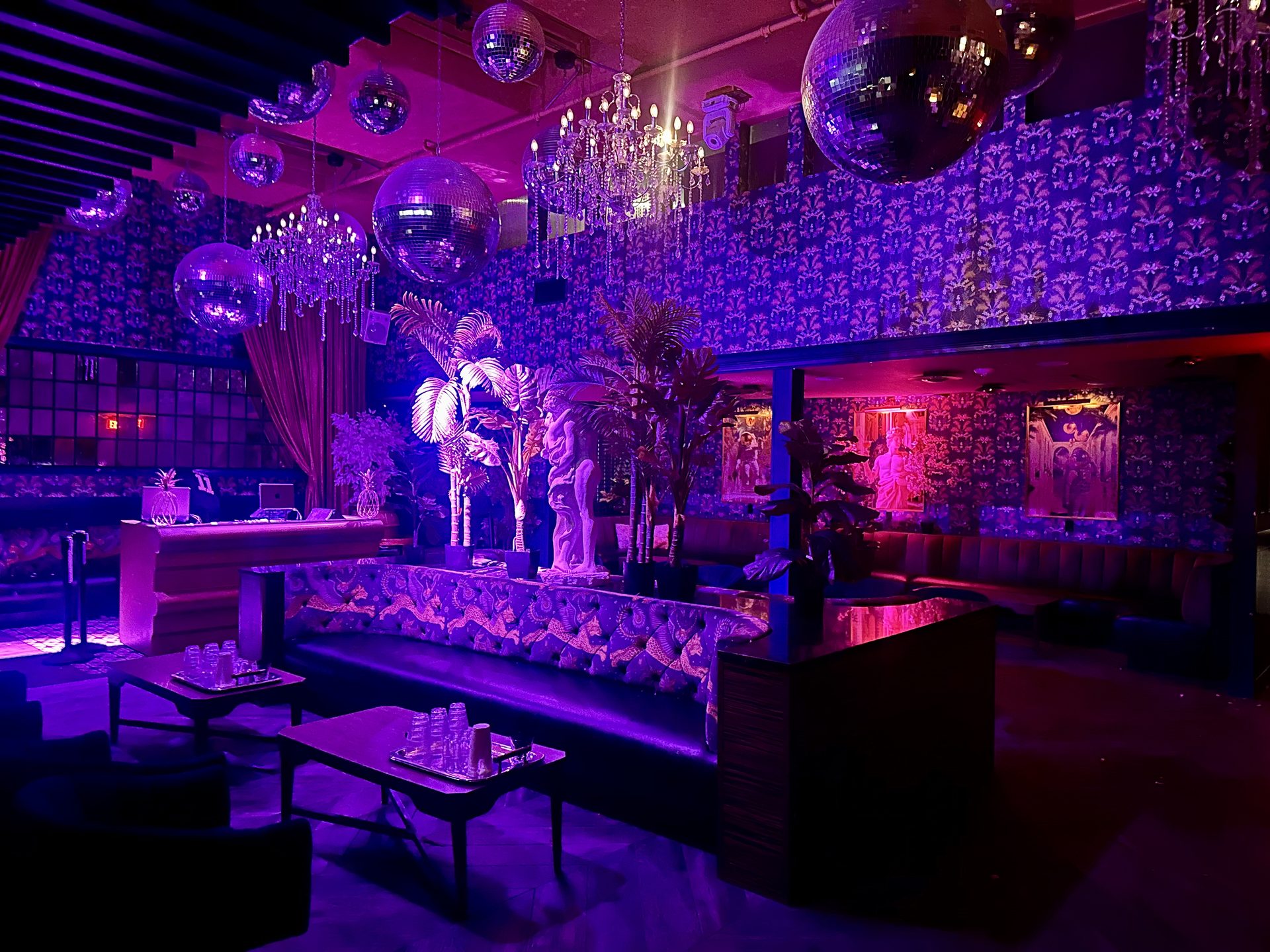 Friends Only Dallas lounge interior with purple lighting, disco balls, chandeliers, and patterned banquettes